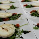 Plastry sera koziego z rukolą i redukcją balsamiczną na eleganckich talerzach