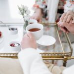 Eleganckie śniadanie we dwoje z herbatą, wypiekami i splecionymi dłońmi