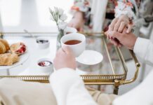 Jakie delikatesy najlepiej sprawdzają się na późne, eleganckie śniadanie we dwoje? Eleganckie śniadanie we dwoje z herbatą, wypiekami i splecionymi dłońmi