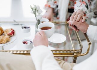 Jakie delikatesy najlepiej sprawdzają się na późne, eleganckie śniadanie we dwoje? Eleganckie śniadanie we dwoje z herbatą, wypiekami i splecionymi dłońmi