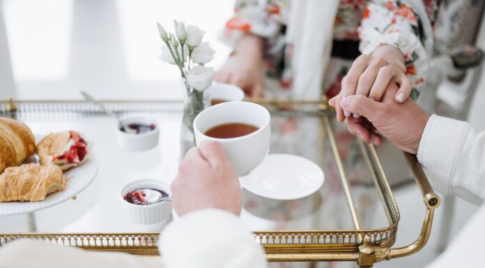 Jakie delikatesy najlepiej sprawdzają się na późne, eleganckie śniadanie we dwoje? Eleganckie śniadanie we dwoje z herbatą, wypiekami i splecionymi dłońmi